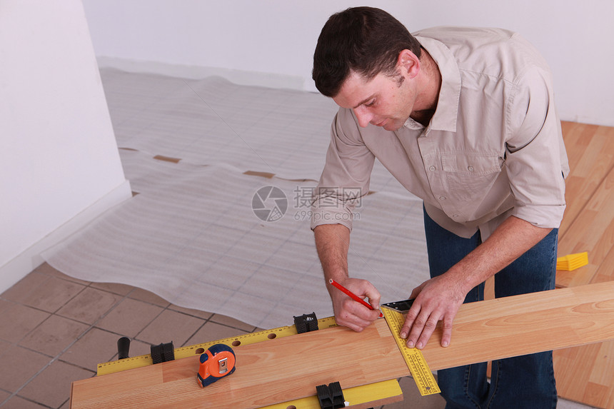 测量压层地板木板的人图片