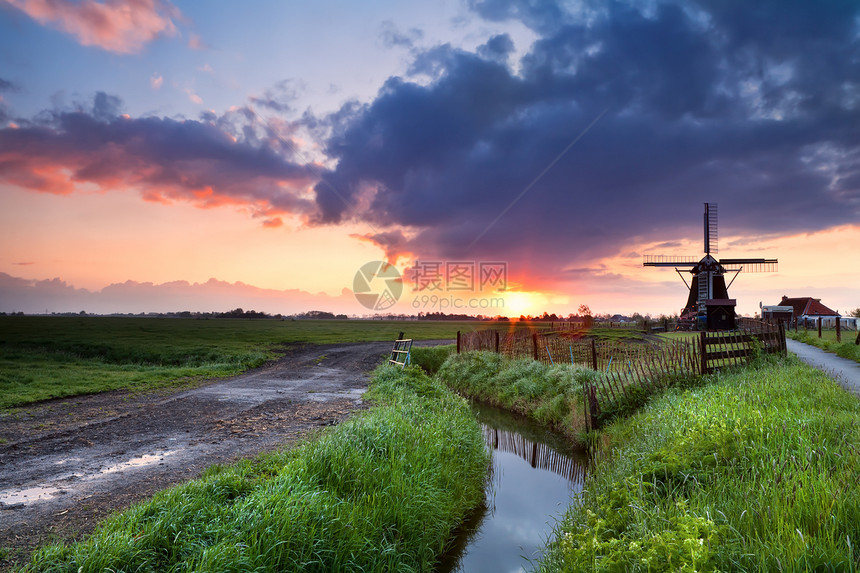 荷兰风车和河流上的热日出图片
