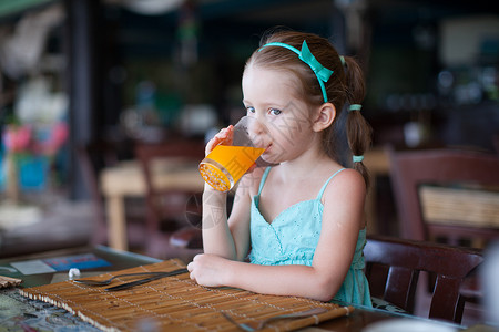 可爱的小女孩在度假餐厅吃早饭 很可爱童年早餐快乐假期女性小吃女孩食物桌子孩子背景图片