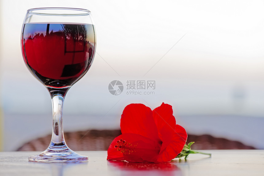日落时 一杯红酒和一朵花图片
