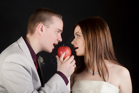 年轻情侣男女咬一个苹果背景图片