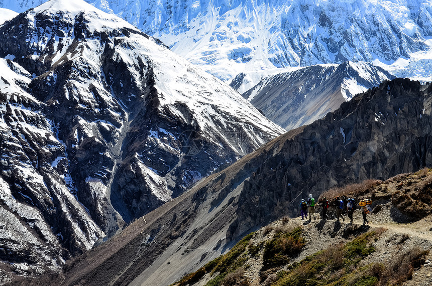 在喜马拉雅山上背着背包的一群山区登山者图片
