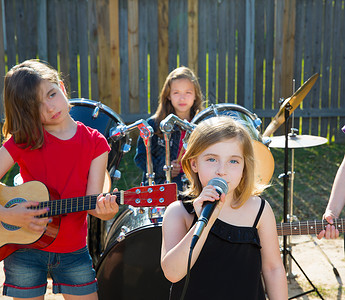 草地音乐会歌唱女歌手在后院现场演奏乐团草地孩子童年音乐会晴天唱歌玩家音乐蓝色女性背景