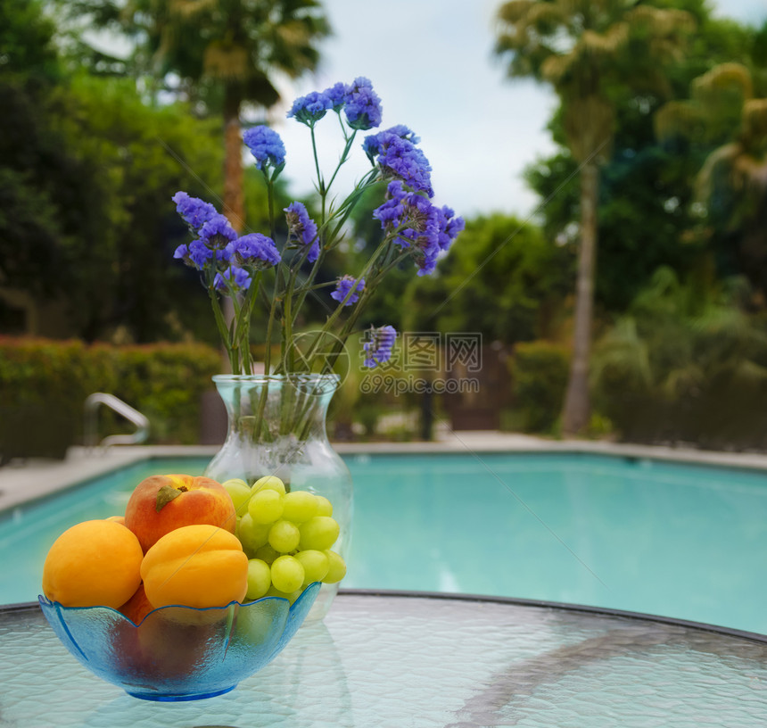 在池边用鲜花和果实散漫花朵盘子游泳池浆果桃子玻璃食物水果杏子图片