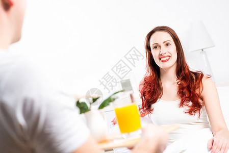 男人把他女朋友的早餐带到床上来闲暇男朋友夫妻家庭酒店果汁微笑休息室食物杯子美丽高清图片素材