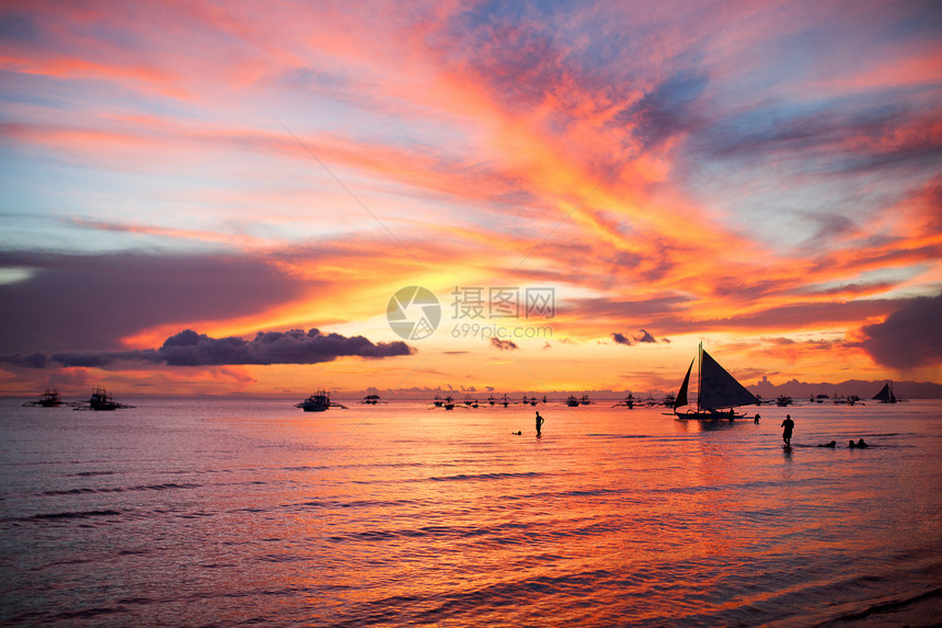 菲律宾博拉凯岛日落前的帆船航行海浪海岸太阳游客活动游艇阳光旅行海洋海景图片