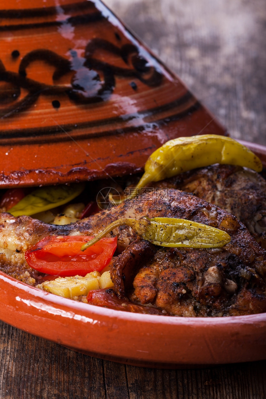 tajine 中的鸡腿家禽牛肉蔬菜陶瓷胡椒盘子食物沙锅土豆木头图片