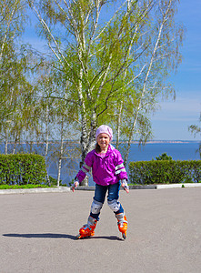 小女孩滑冰滑溜冰公园森林孩子蓝色女性乐趣滚筒活动膝盖骨快乐背景图片