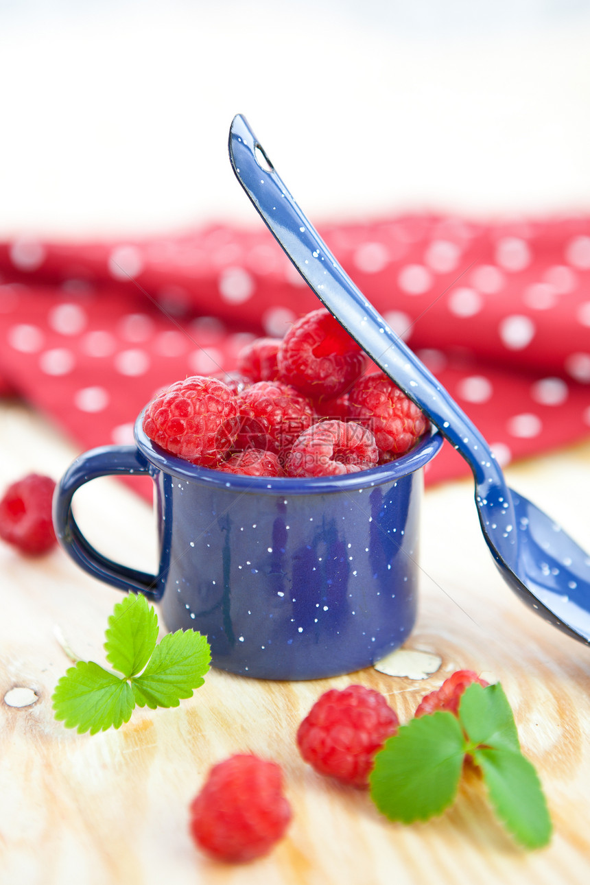 新鲜果子在小旧水桶里浆果覆盆子果味水果粉色红色树叶叶子桌子勺子图片