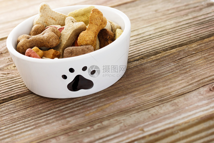 狗饭碗中的狗食品棕色盘子犬类小狗小吃零食甜点狗饼干爪子白色图片