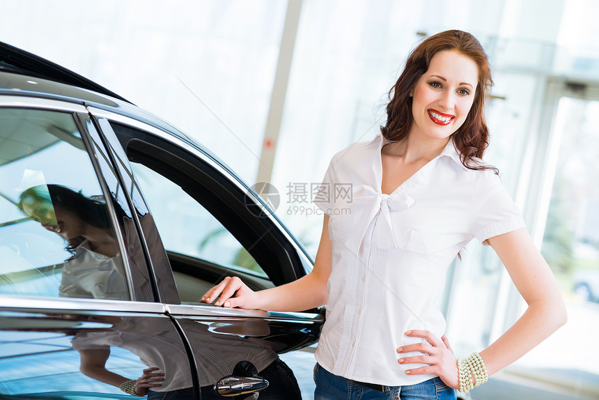 站在汽车旁边的年轻妇女引擎微笑经销商商业司机服务运输车辆车库女士图片