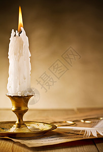 老实像燃烧的蜡烛陈年的黄铜烛台 桌上放着火辣的蜡烛背景