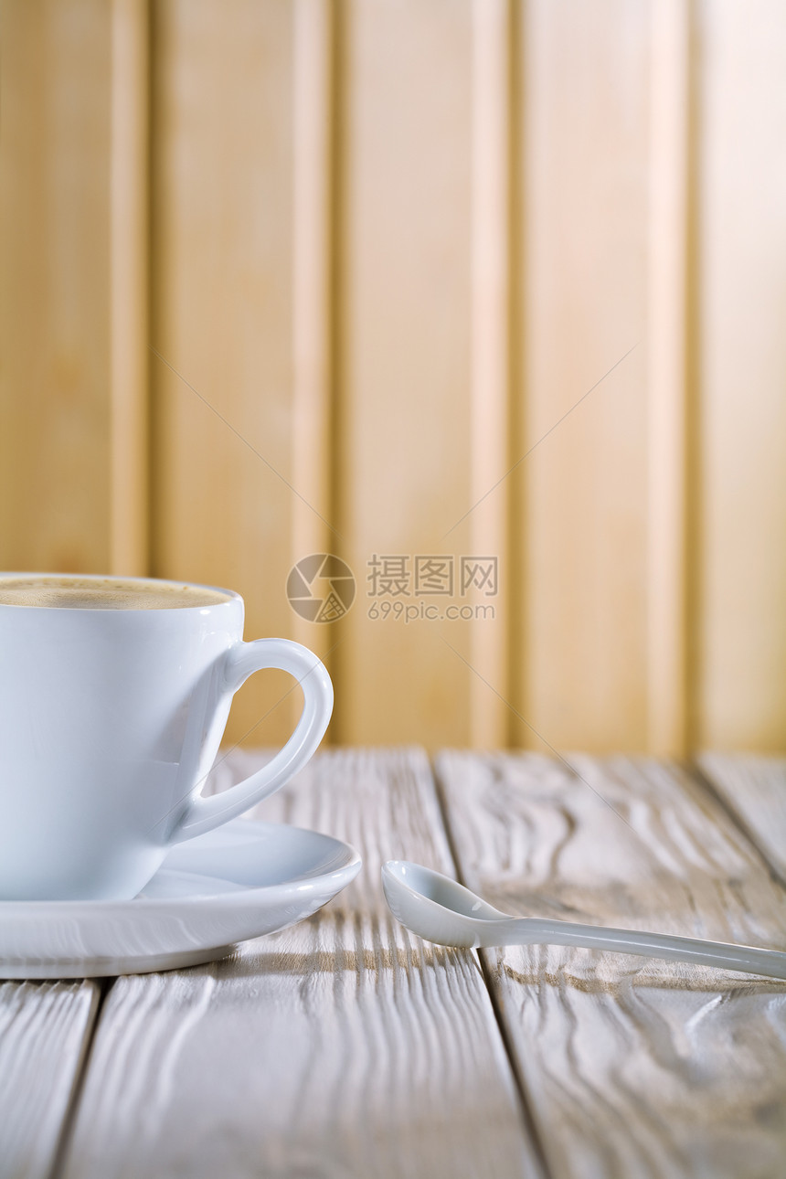 旧桌上的白咖啡杯和勺子图片