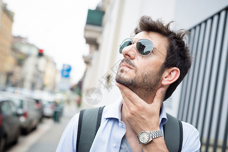 男人在街上行走日常生活城市城市生活胡子太阳镜游客街道背景图片