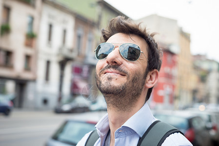 男人在街上行走城市生活日常生活微笑太阳镜胡子游客城市街道背景图片