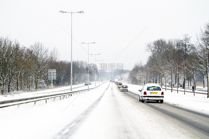 在荷兰阿姆斯特丹的雪中驾驶运输特丹暴风雪车辆交通街道图片