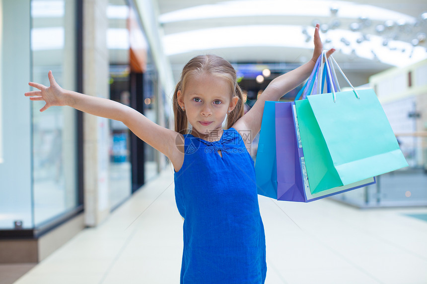 在商场上拿着购物袋的小快乐女孩的肖像奢华销售微笑乐趣市场购买者快乐购物中心青年幸福图片