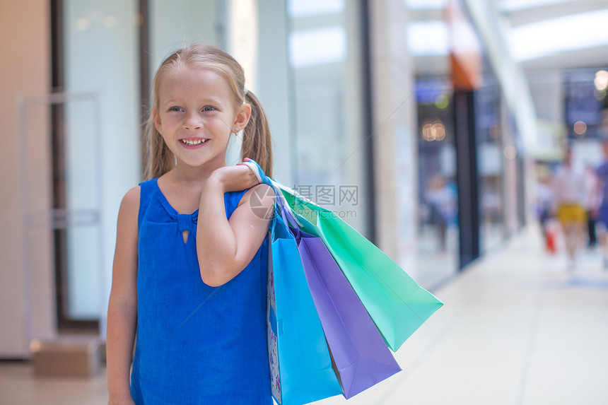 在商场上拿着购物袋的小可爱女孩的肖像购买者闲暇青年幸福奢华市场童年生活购物者喜悦图片