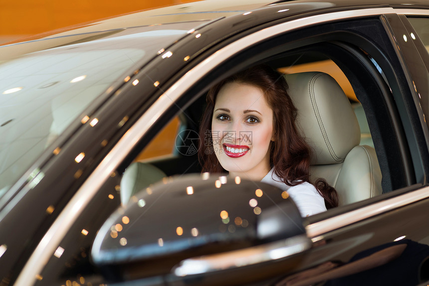 女青年在展厅的新车里运输发动机驾驶手指欢乐旅行人士考试成就司机图片