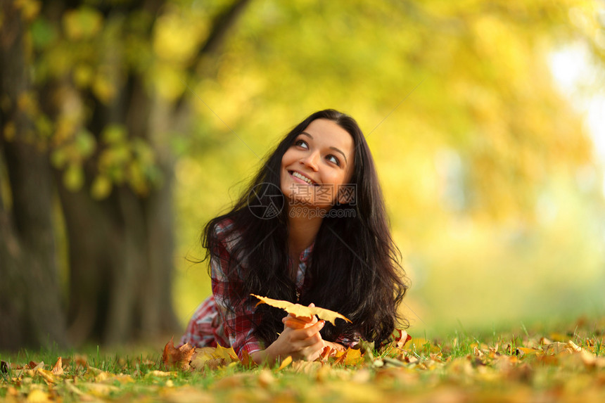 秋叶中的妇女脚尖女孩女性乐趣微笑头发感恩橙子毛衣团体季节图片