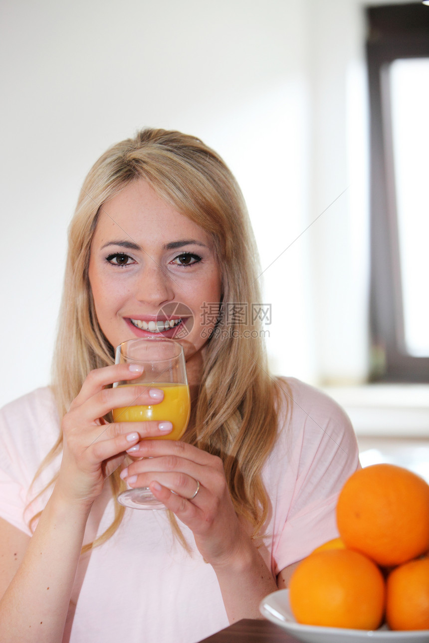 喝新鲜橙汁的年轻女子图片