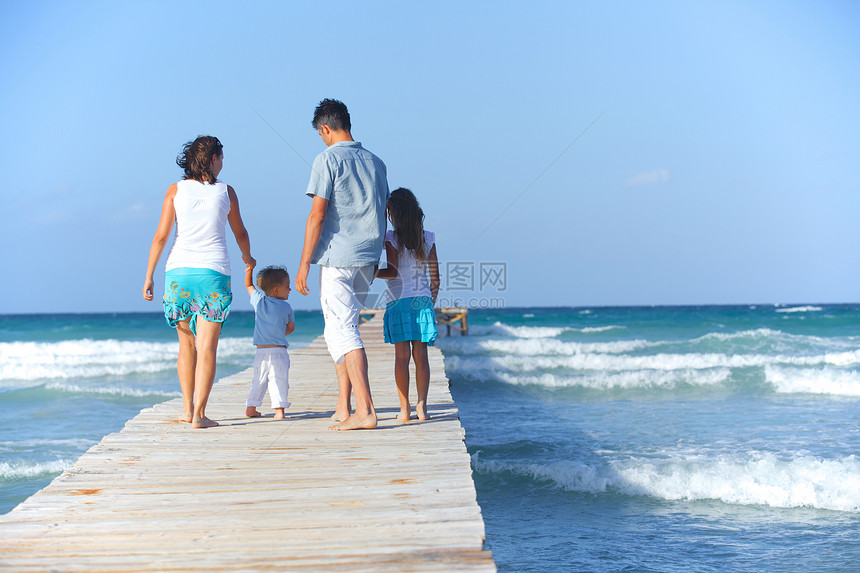 家庭在木制码头上假期女儿海洋爸爸成人孩子享受女士男性乐趣图片