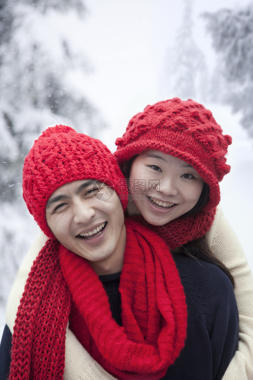 雪中年轻夫妇乐趣服装友谊衣物活动围巾男朋友微笑幸福女性图片