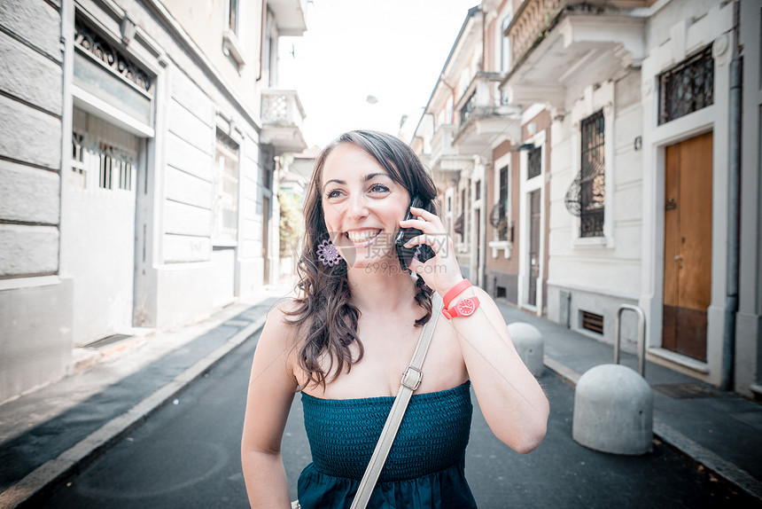电话上美丽的女人相机街道呼唤城市手机沟通女士微笑幸福图片
