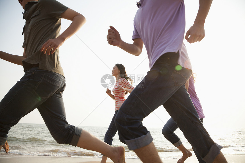 朋友在海滩上奔跑服装耀斑赛车跑步乐趣摄影旅行海洋友谊腹部图片