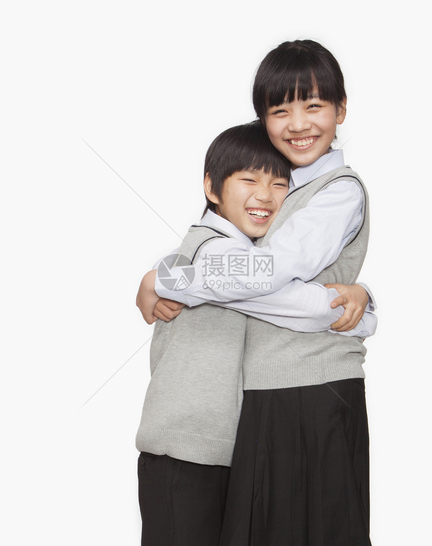 哥哥和妹妹拥抱棕色微笑家庭男孩们幸福姐姐享受团结童年校服