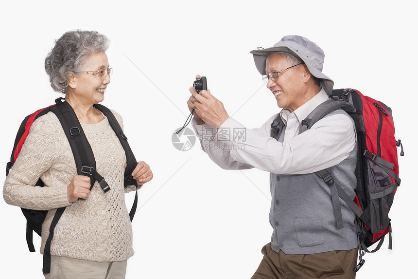 高年男子用数码相机拍摄妻子的照片图片