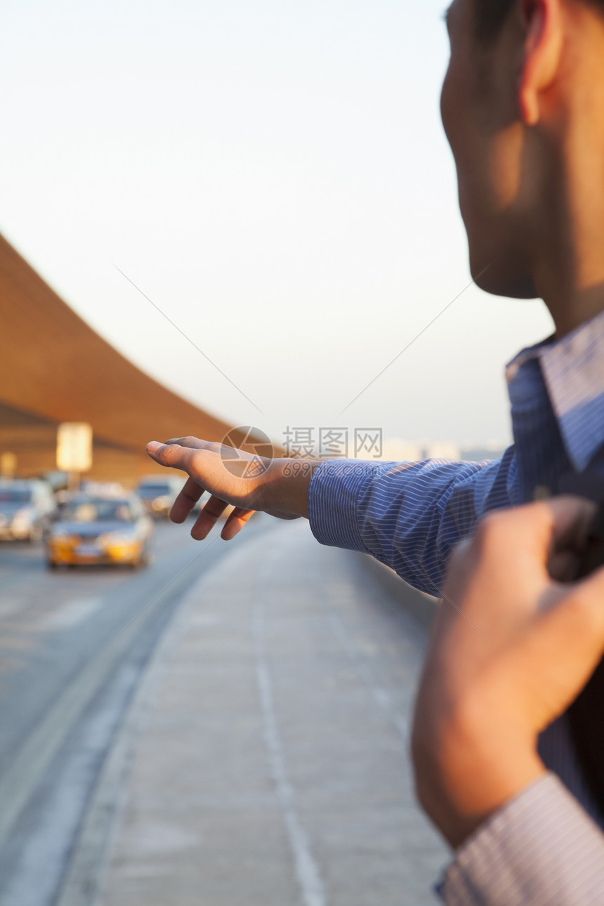 年轻旅行者在机场外叫出租车的年轻人图片