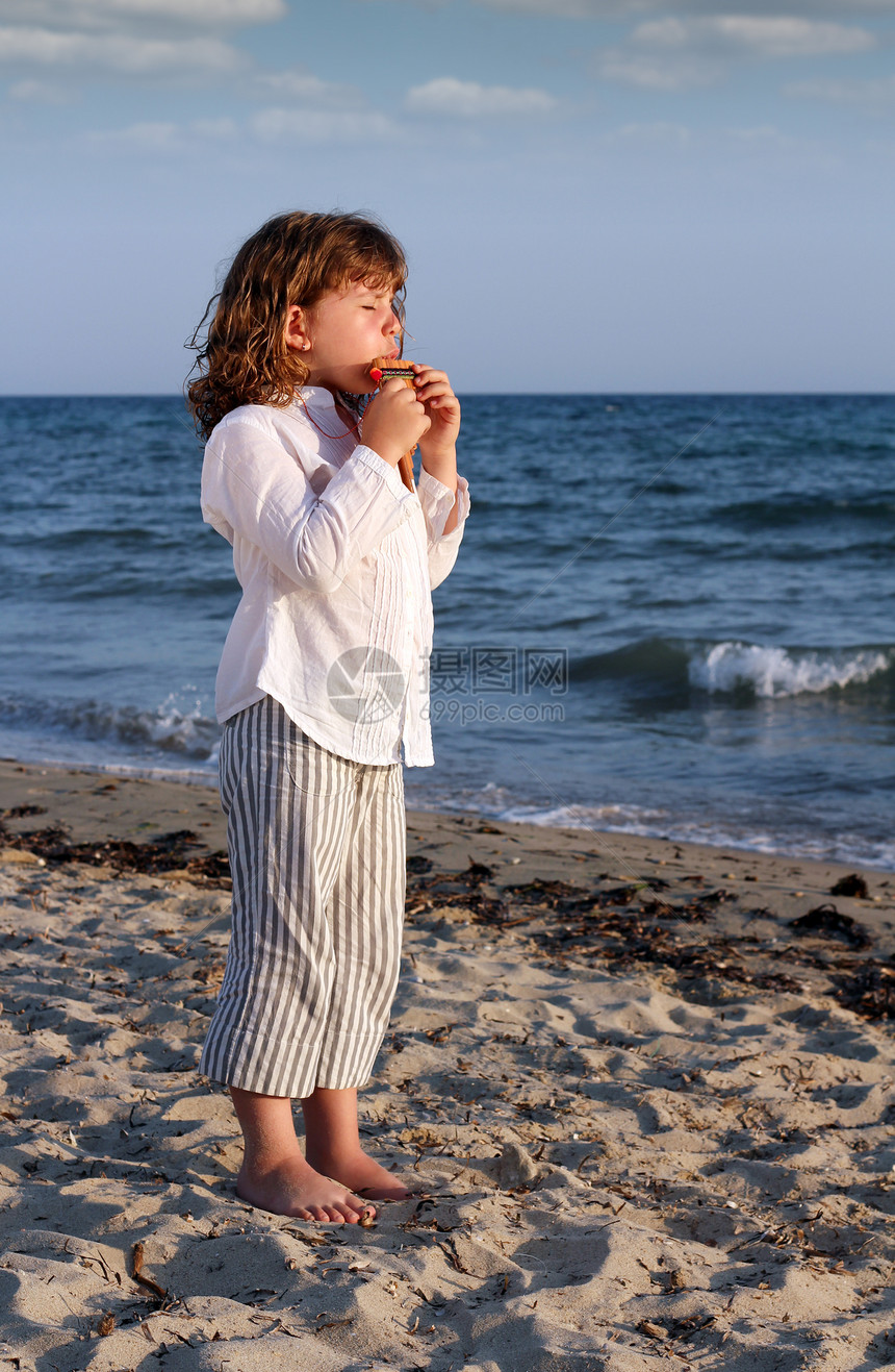美丽的小女孩在沙滩上打锅炉管图片