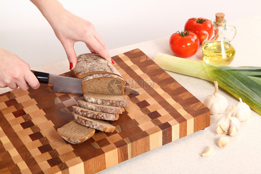 切割板上的产品植物油木板木头菜板厨房韭葱面包食物蔬菜棕色图片