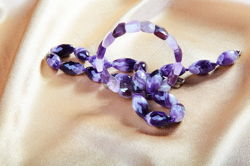 紫花玻璃上的珠珠和手镯 从织物上对着首饰项链金子女性礼物材料工作室纺织品女孩奢华图片