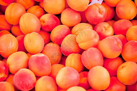 鲜橙红杏仁桃子 在市场上的宏观闭市收成美食小吃营养甜点金子农业维生素饮食健康饮食背景图片