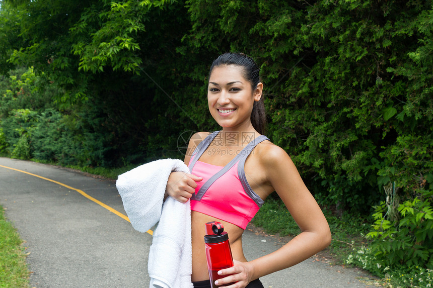 合适的女人有水和毛巾帽衫活力慢跑者运动员拉丁训练身体女性水瓶夹克图片