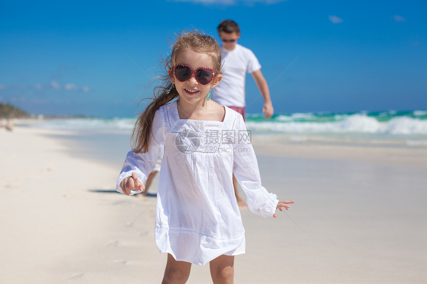 热带海滩背景中可爱女孩和他父亲与小妹妹的画像图片