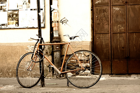 旧自行车站在城市的街道上骑术网格背景图片