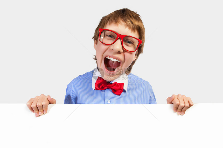 红色戴红眼镜的男孩持有白方快乐推介会眼镜广告牌领结木板海报手臂教育幸福图片