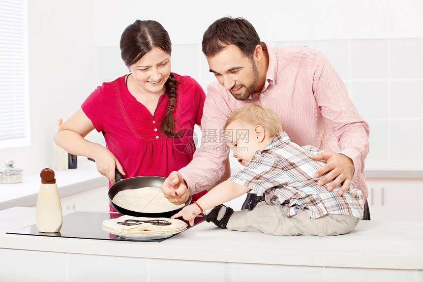 家人在厨房做煎饼孩子儿子巧克力父亲微笑母亲美食平底锅图片