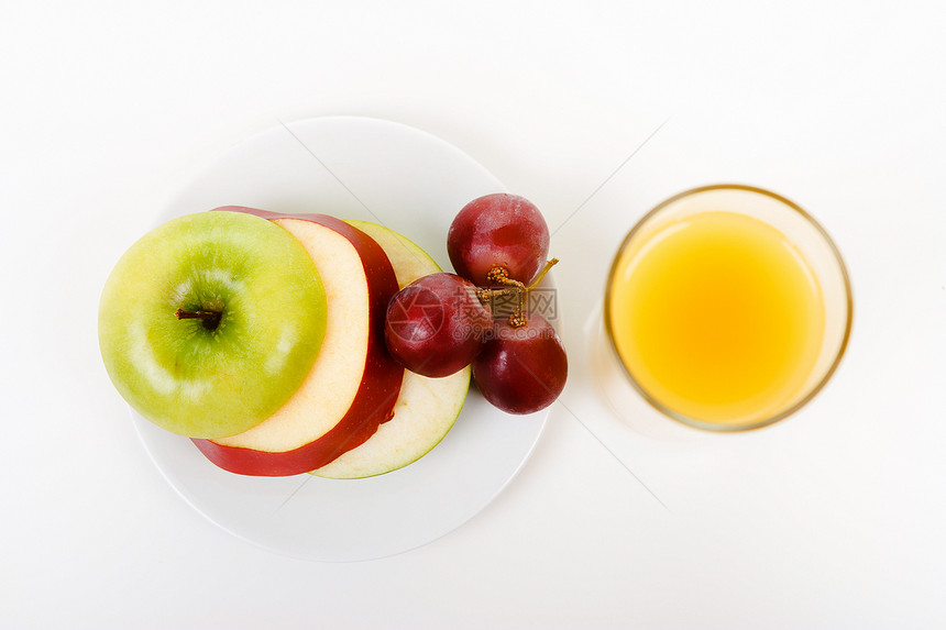 苹果 盘子上的葡萄和一杯橙汁图片