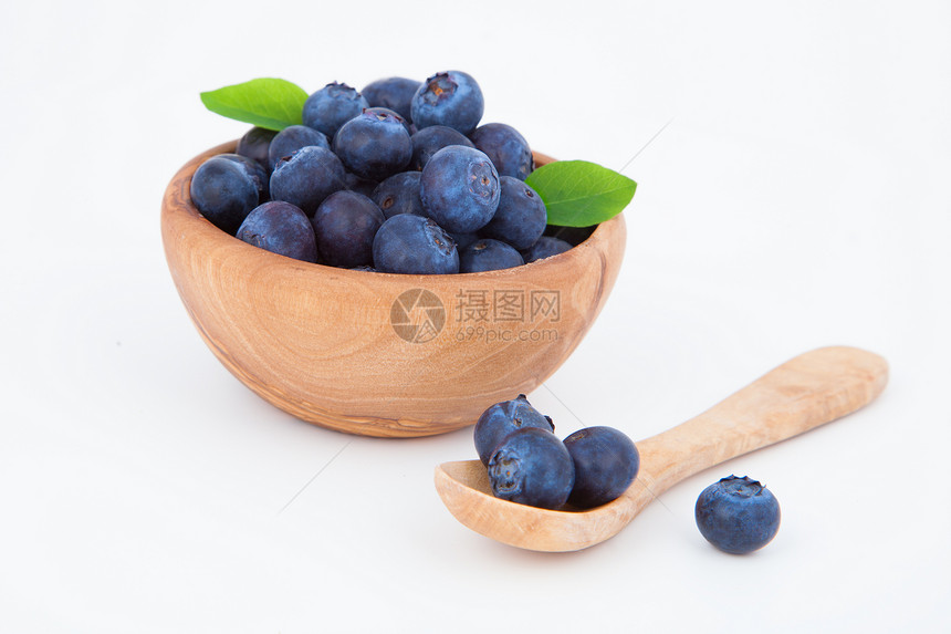 新鲜蓝莓在木碗里 在白色背景上图片