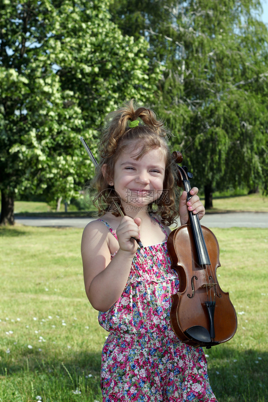 快乐的小女孩 在公园的小提琴图片