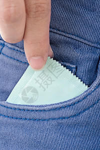 在口袋里拉安全套避孕套棉布保健安全控制乳胶欲望男人蓝色性别背景图片