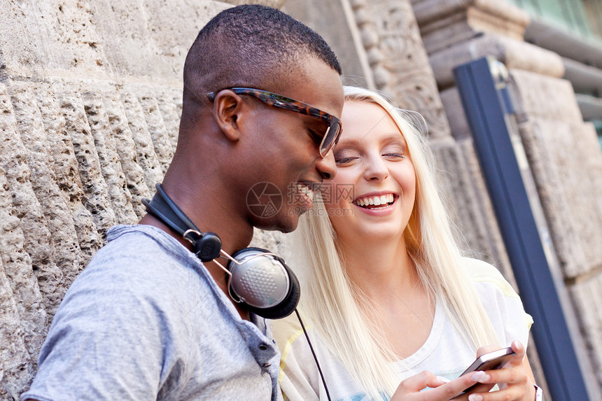年轻快乐的情侣在城市夏季玩得开心微笑建筑女性学生街道青少年夫妻蓝色朋友们友谊图片