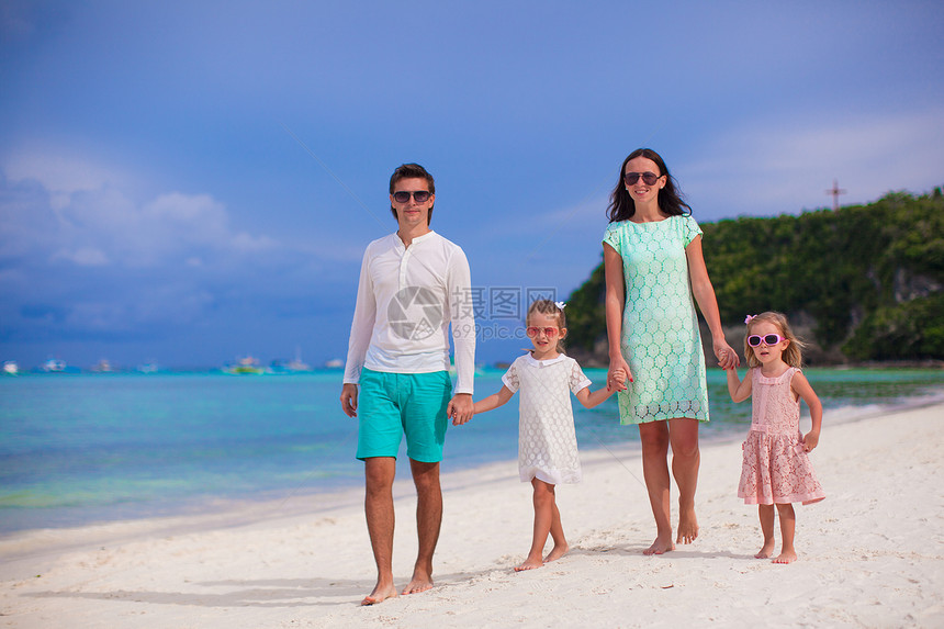 年轻美丽的家庭 有两个孩子在热带度假中走过图片