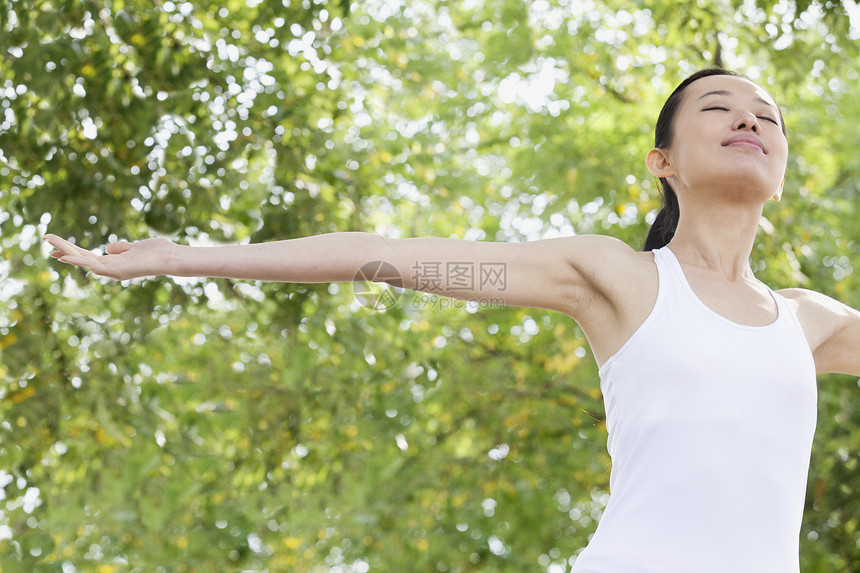 公园中放松的女青年运动拉伸黑发运动员女性自由幸福手臂训练活力图片