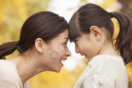 与母亲和女儿面对面毛衣家庭喜悦女性幸福叶子季节棕色单亲衣物自然高清图片素材