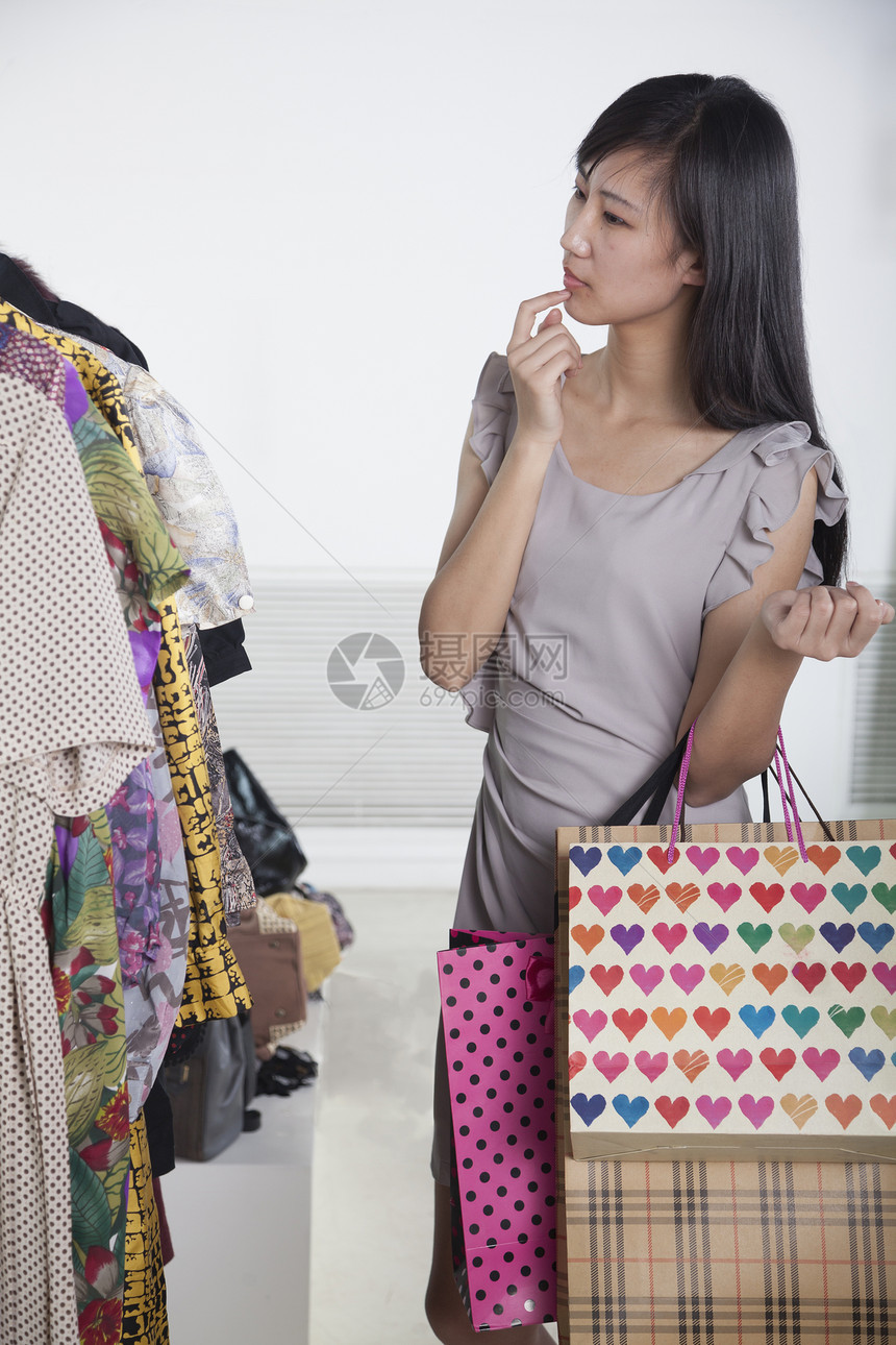 在时装店买袋的年轻女青年服装店女人味销售零售棕色魅力衣架女性休闲摄影图片